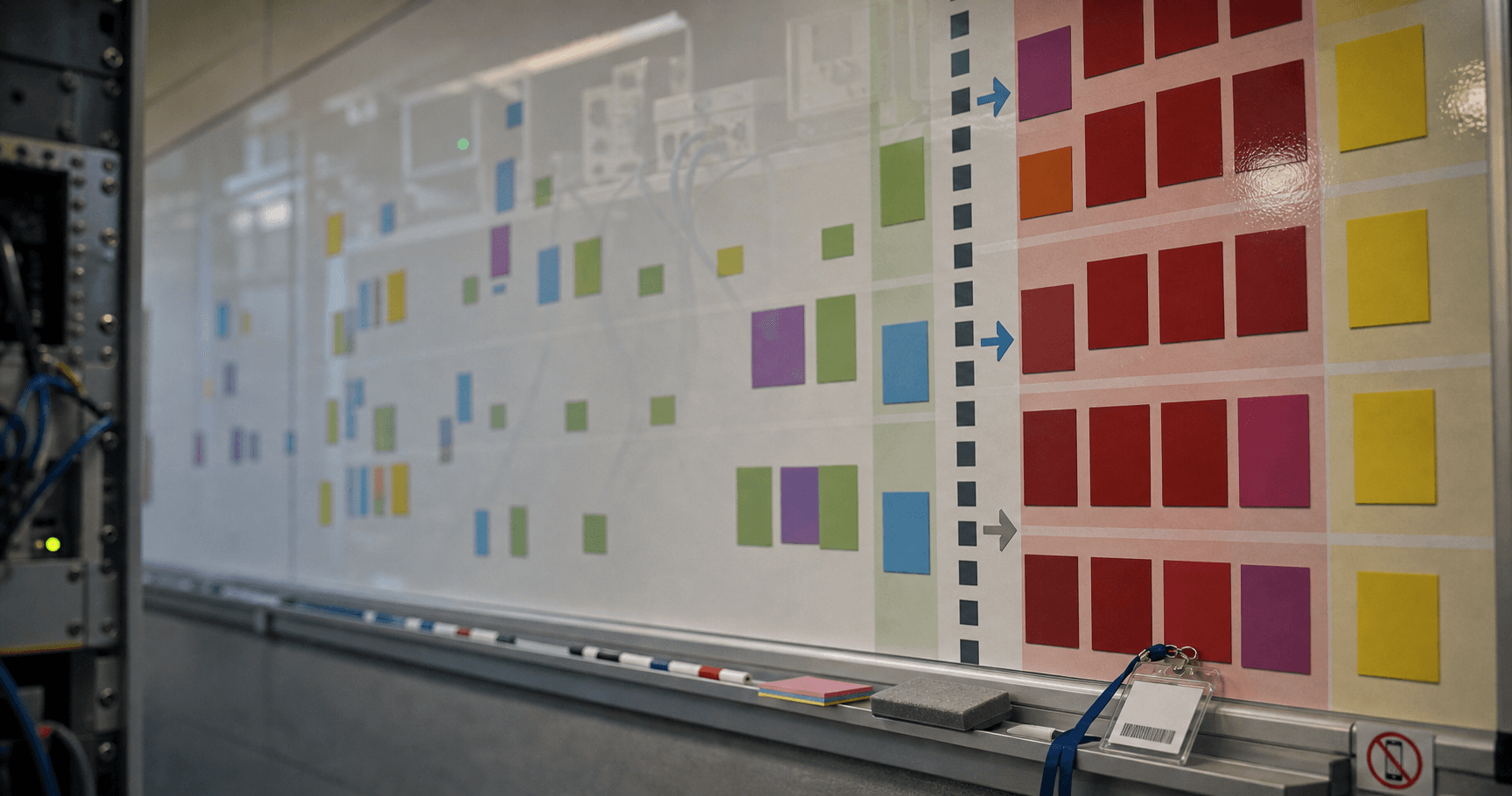 ITAR access whiteboard in defense lab, badge on ledge and lab gear reflected